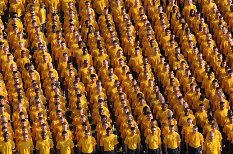community of people standing in yellow shirts