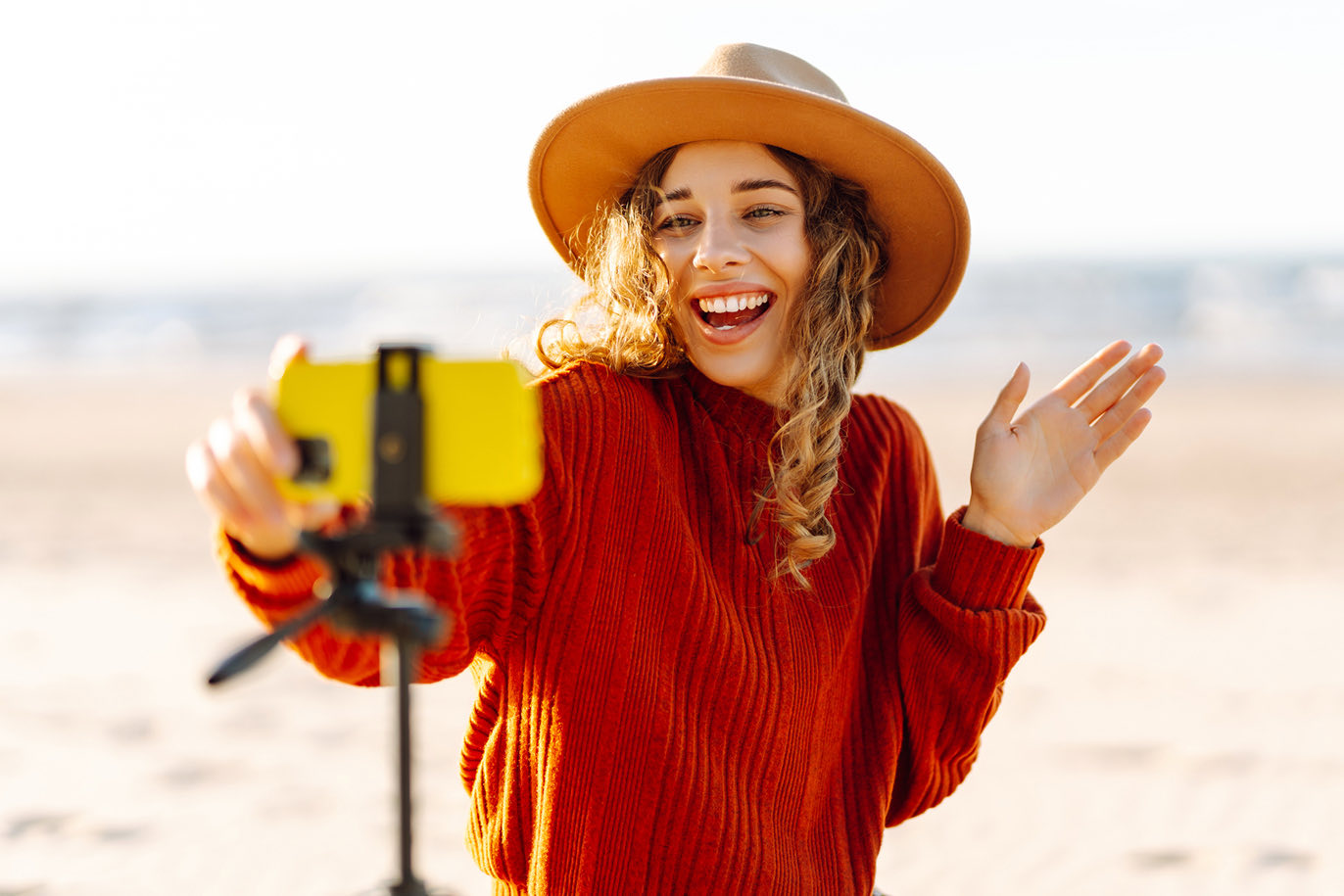 Happy woman vlogging on beach