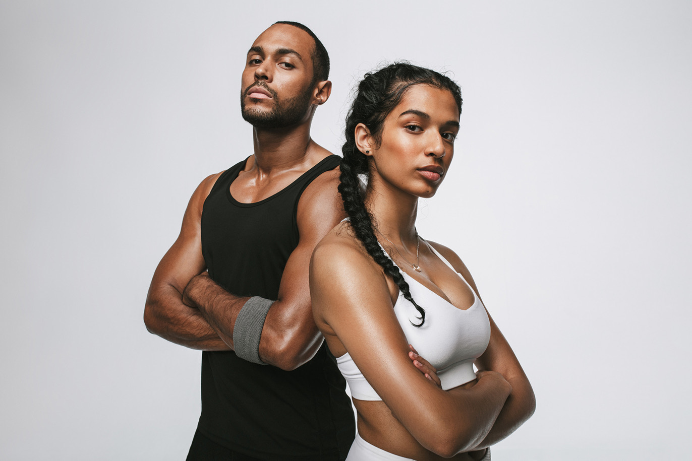 Athletic couple posing back-to-back