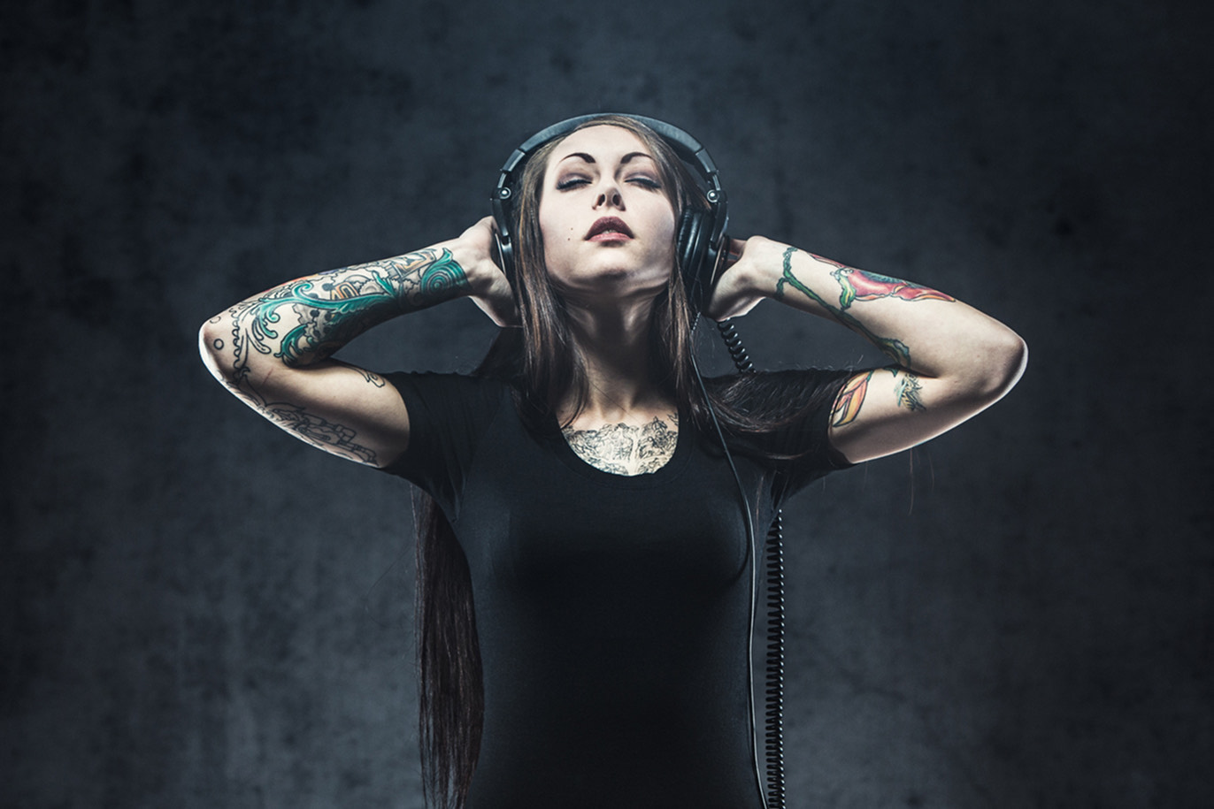 Tattooed woman wearing large headphones
