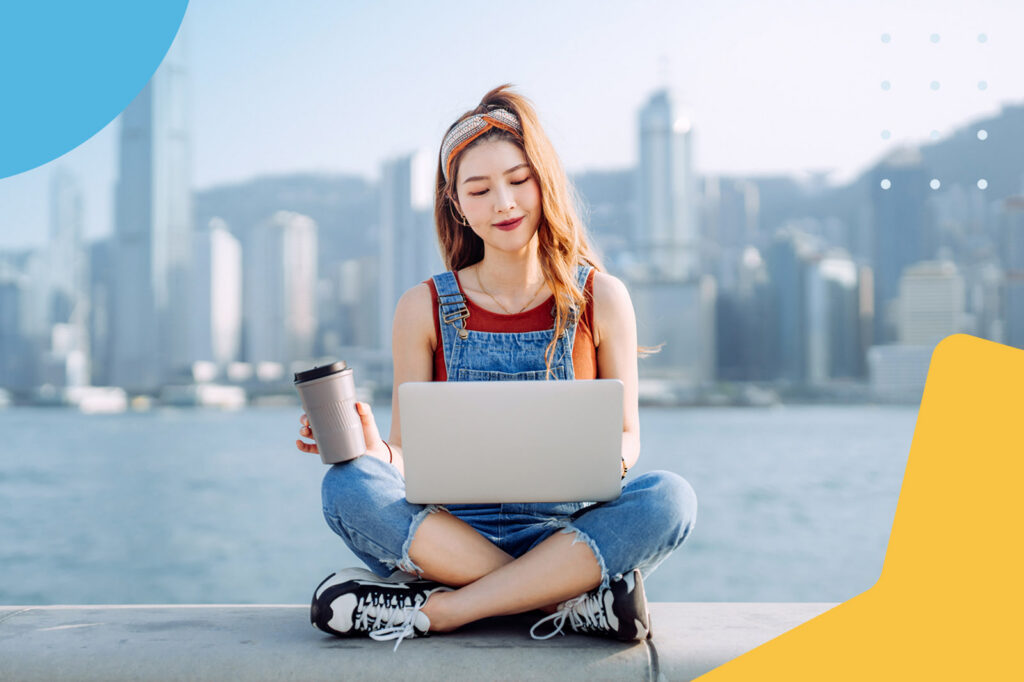 Woman using laptop near harbor