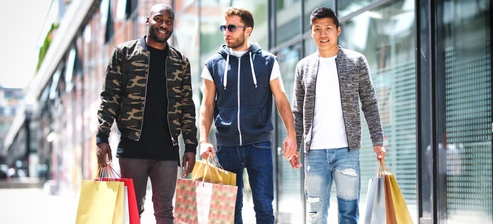 Three guys walking on street after shopping