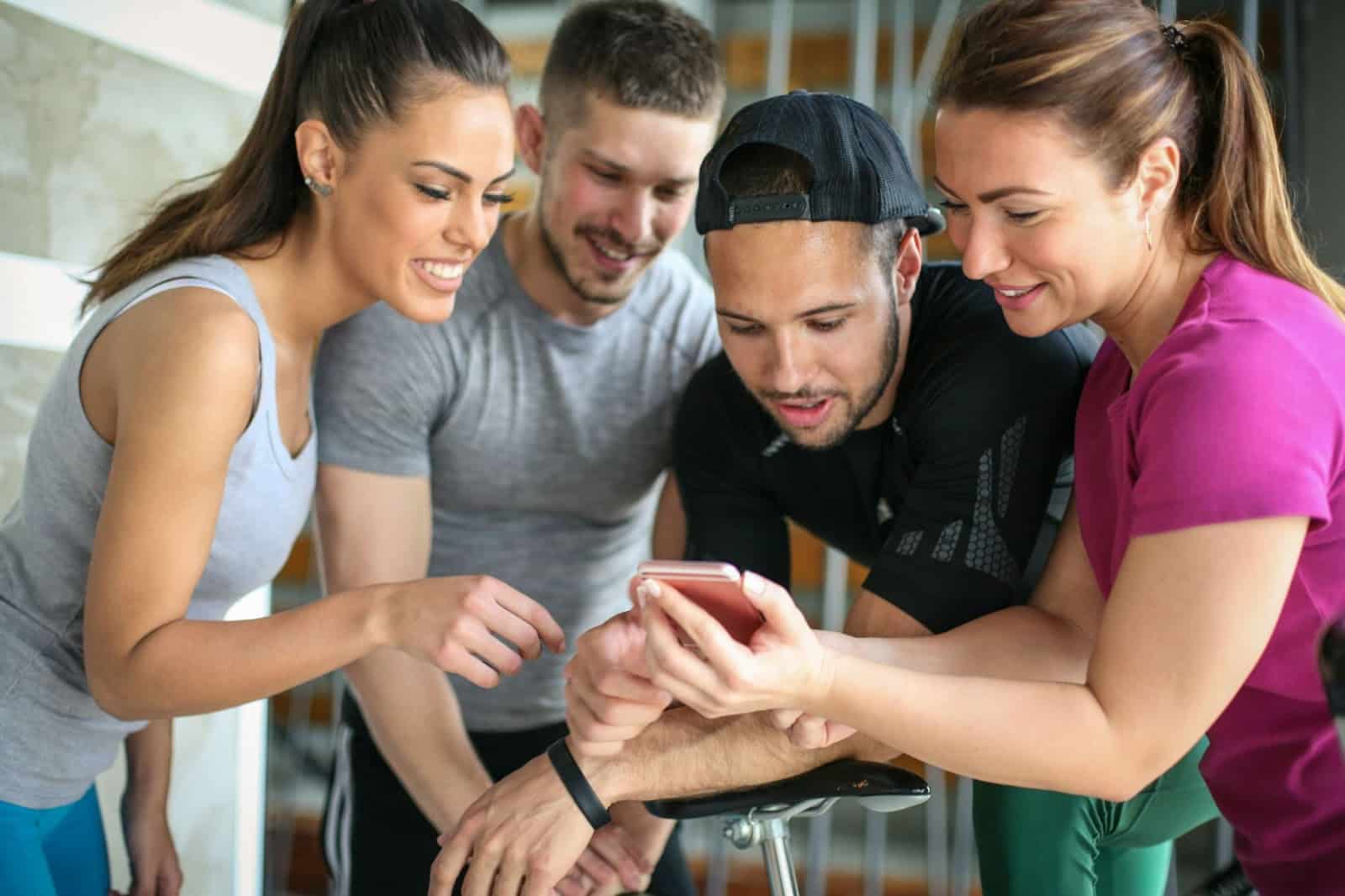 People looking at phone at gym