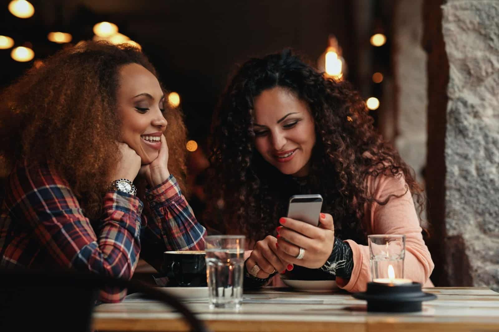 Women eating in restaurant on phone
