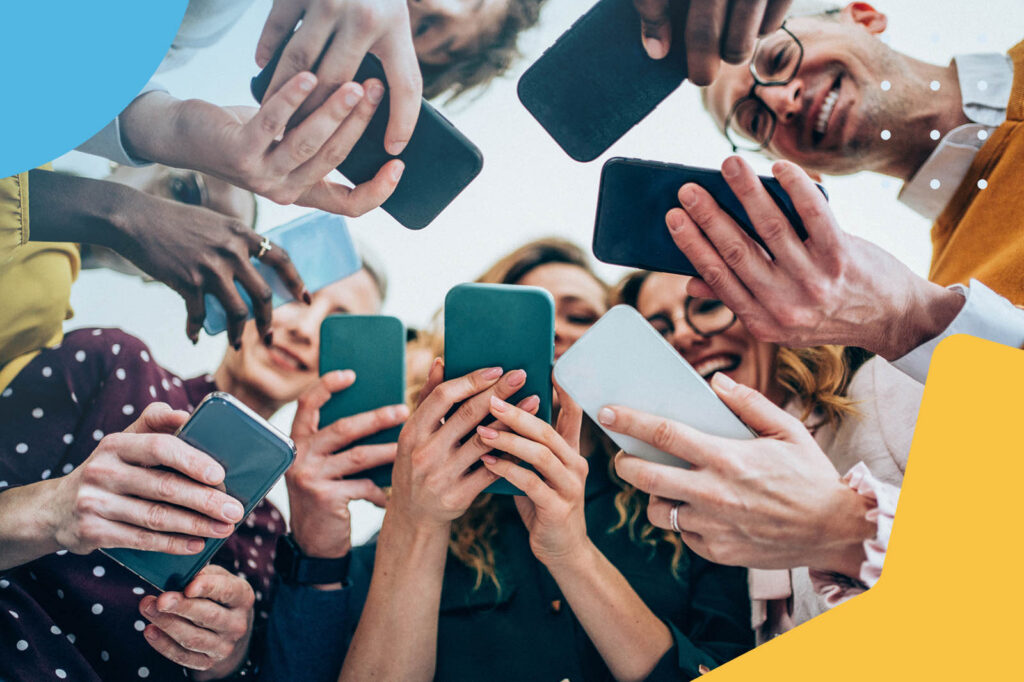 Group of people taking a collective selfie with smartphones