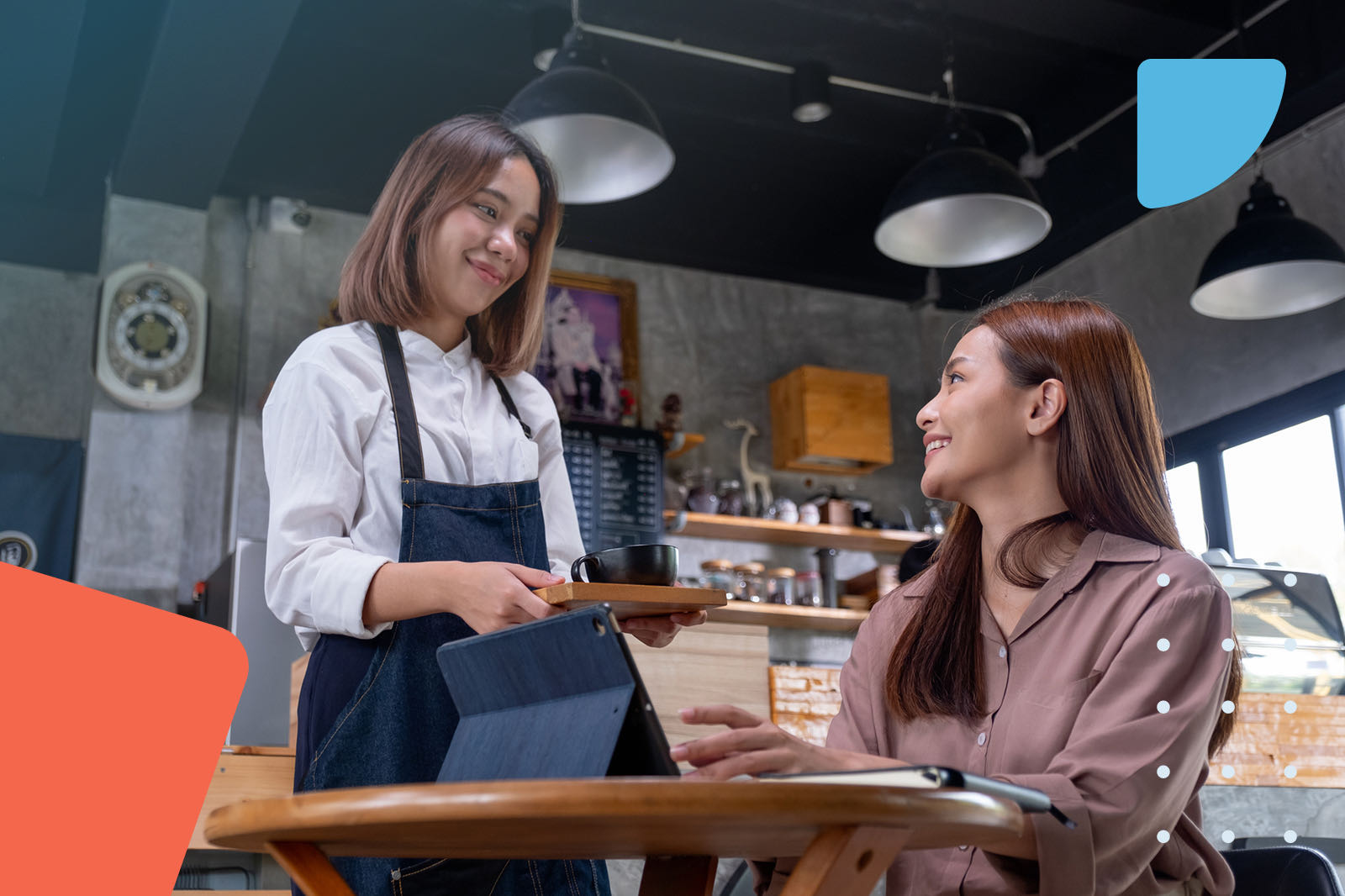 Waitress serving coffee to a customer with a tablet at a cafe