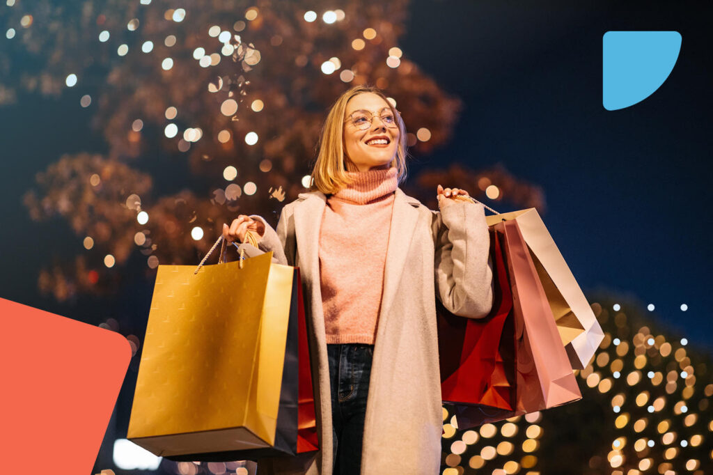 Happy woman with shopping bags against festive lights