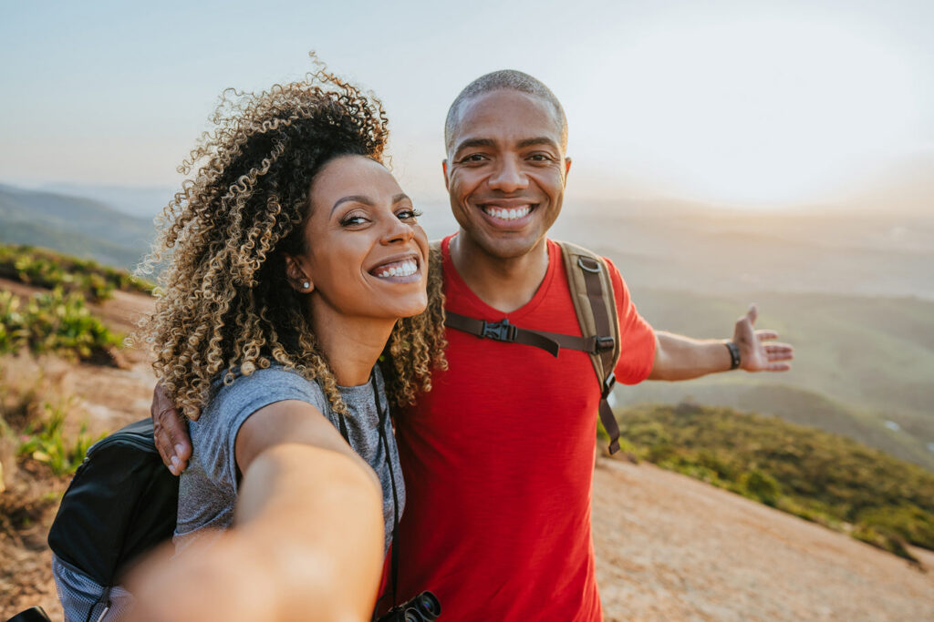Couple taking a selfie while hiking at sunset