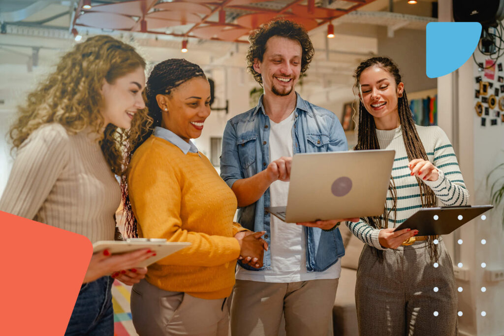 Diverse business team collaborating around a laptop