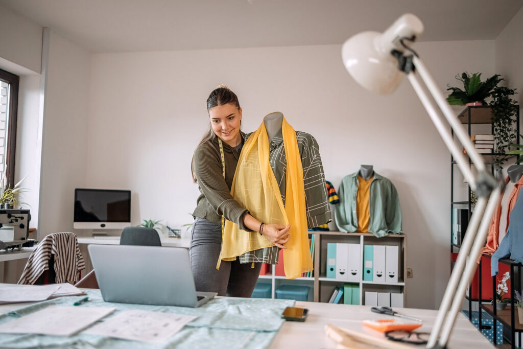 Fashion designer holding clothes in a home studio