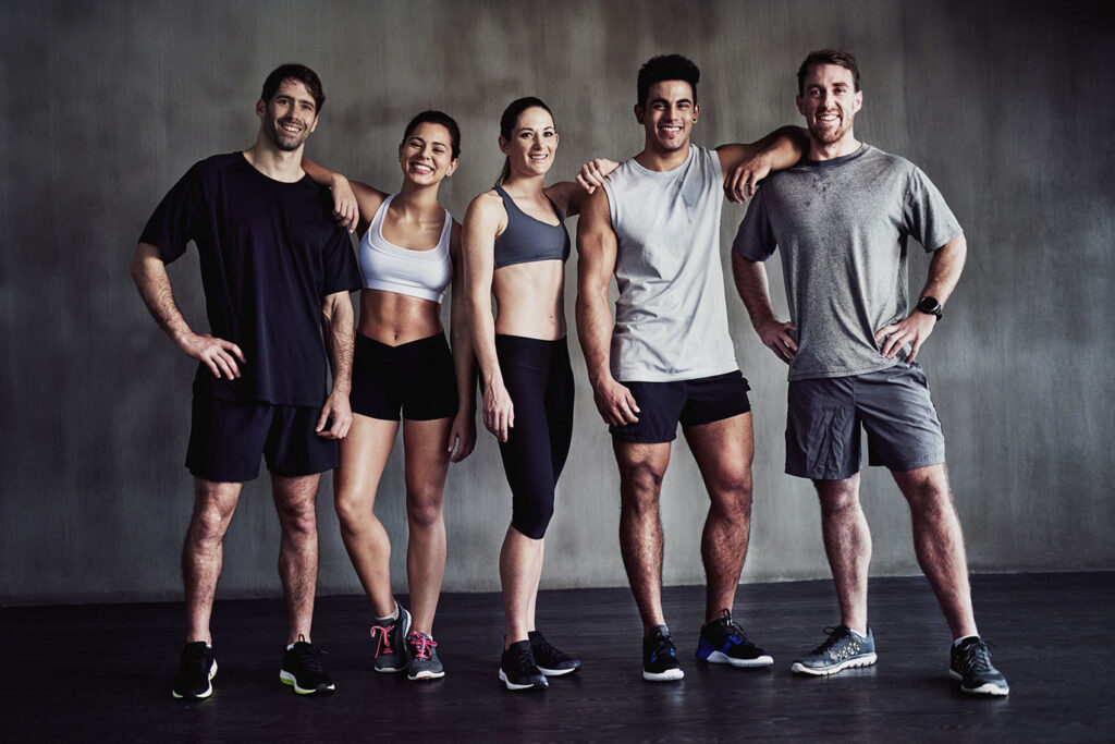 Group of fitness friends posing in a gym