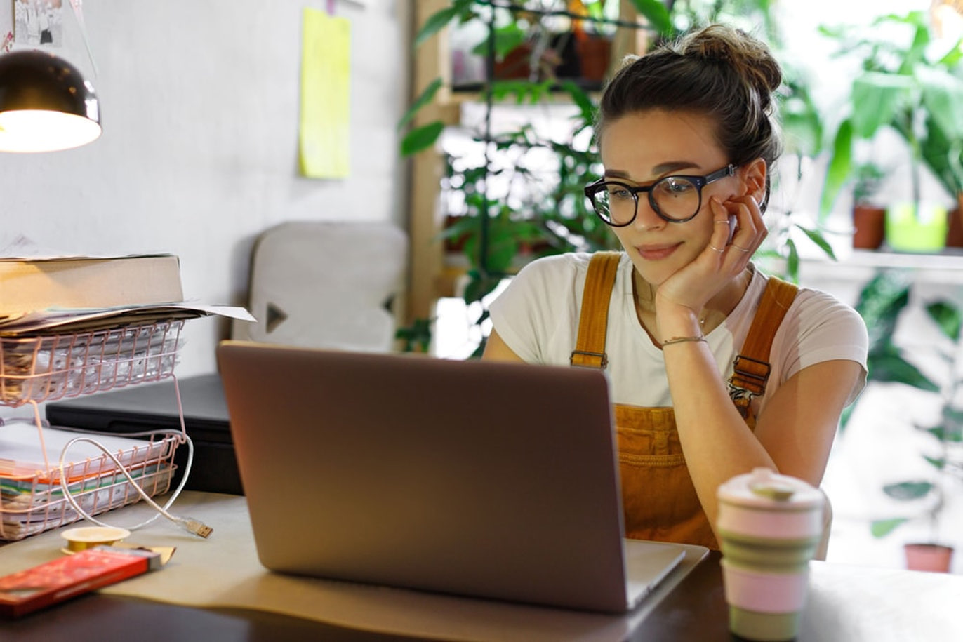 Young woman working on a laptop in a bright office