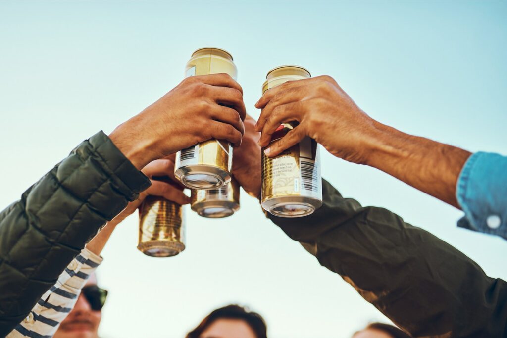 People holding beverage cans