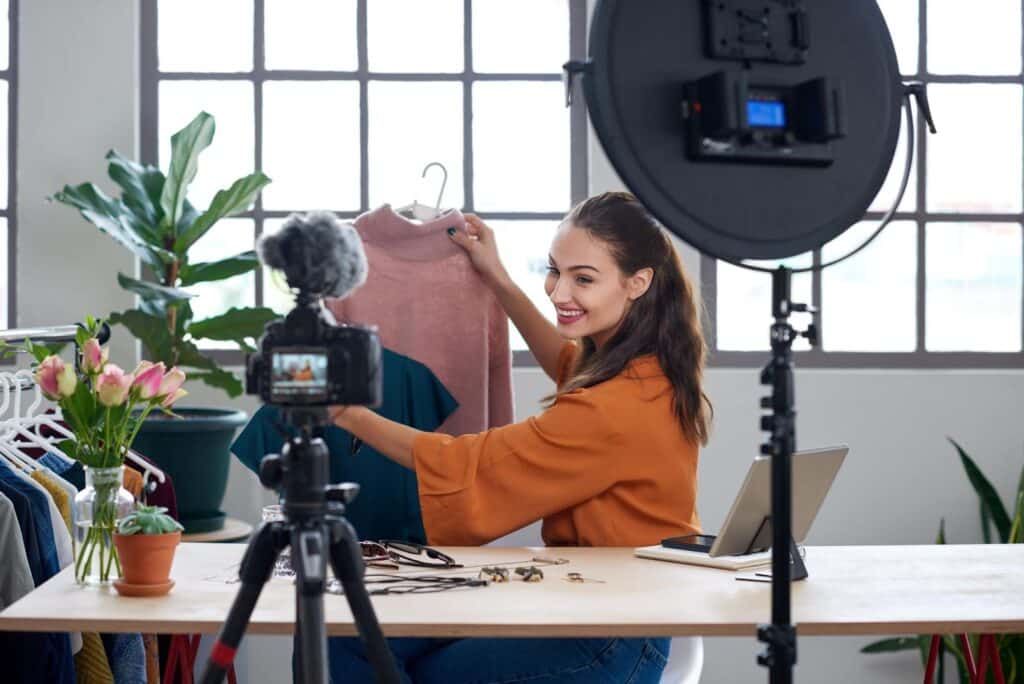 Woman holding shirt filming video