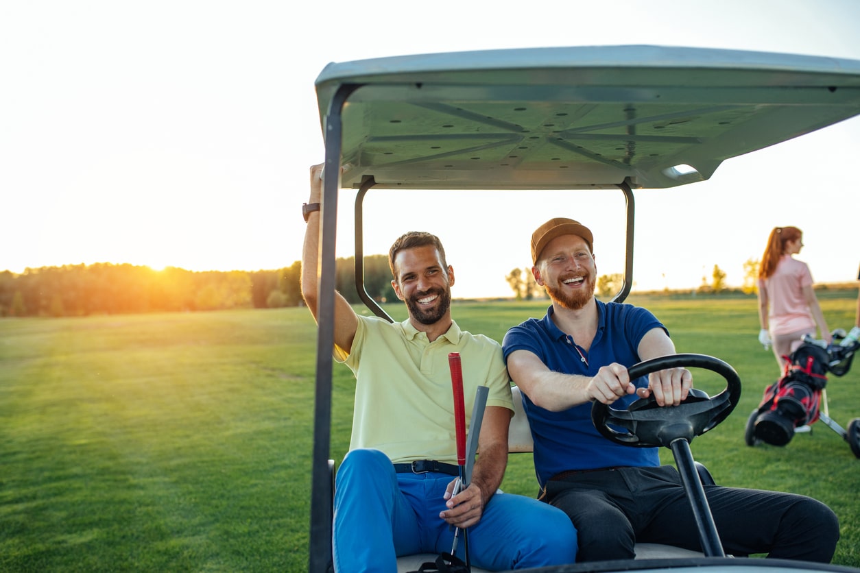 Ambassadors driving a gold cart