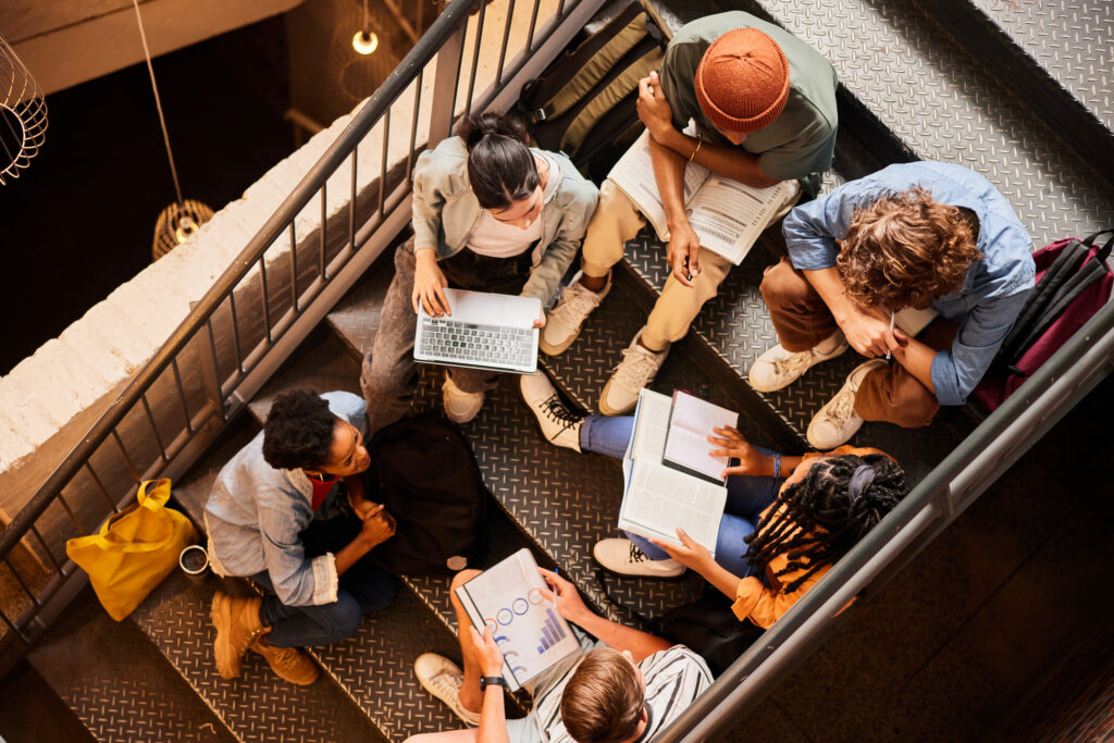 Ambassador Programs for Small Teams: Strategy and Structure 3 High angle view of a diverse group of young college students studying together on stairs at school between classes