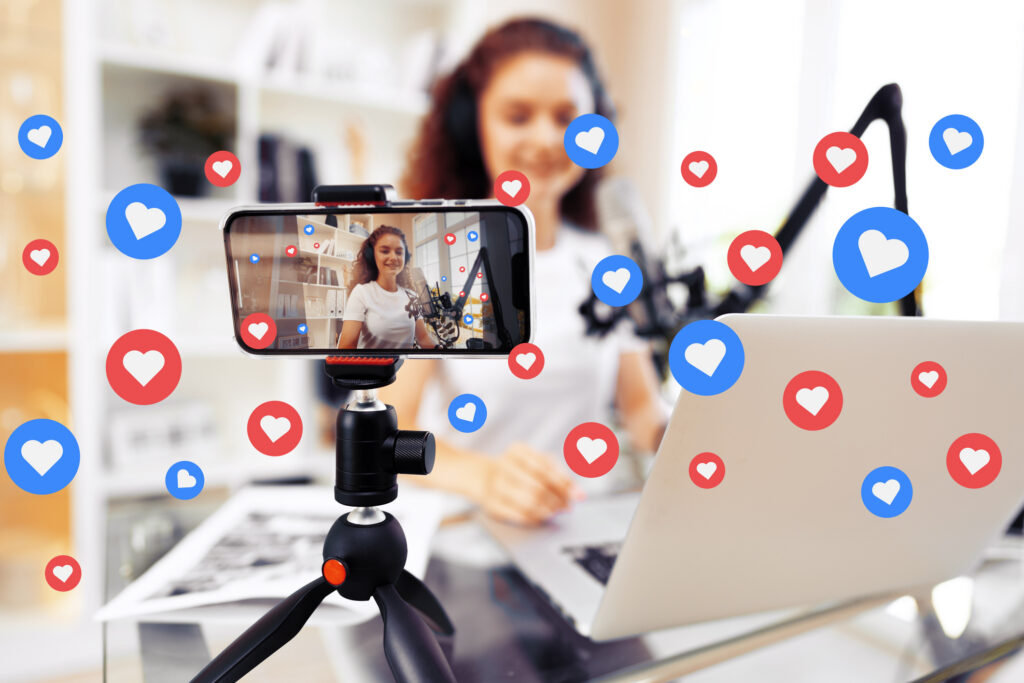 Brand ambassador records a podcast at home with a smartphone and laptop, engaging the audience.