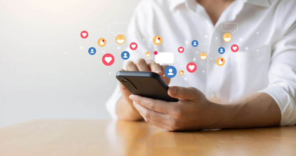 Person holding a phone with social icons like likes and comments floating above it, the kind of engagement influencer tiers are built around