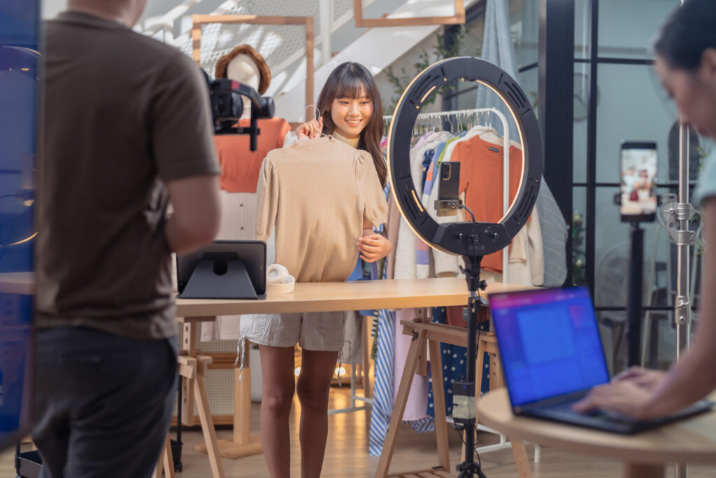 Content creator filming a clothing haul on camera with a ring light and crew nearby, the kind of setup that separates influencer tiers by scale 