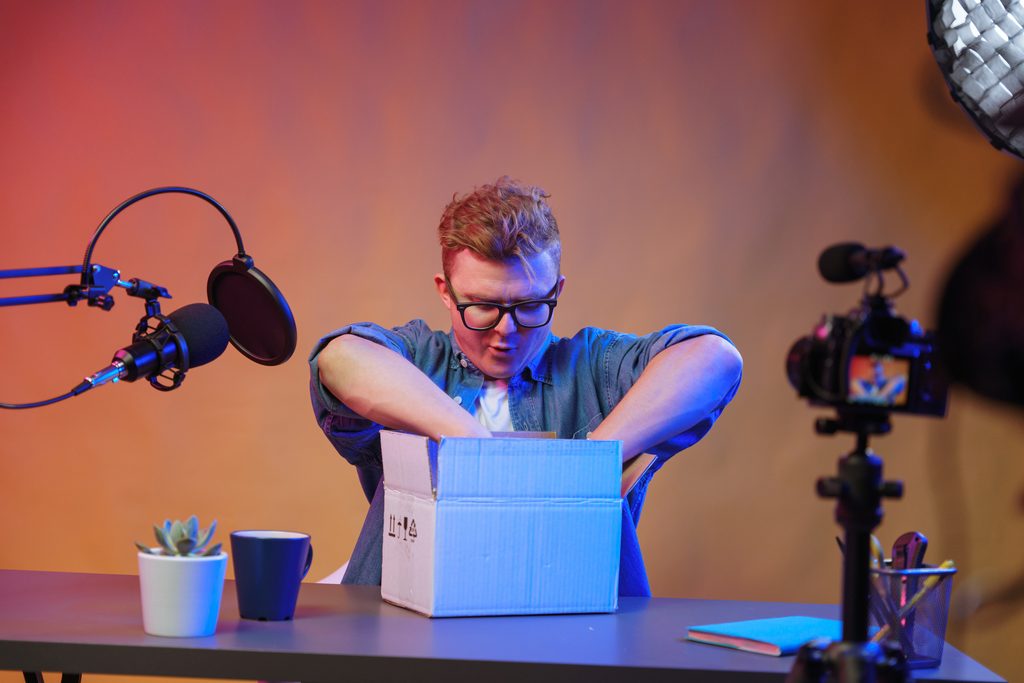 Creator filming an unboxing video for a brand ambassador strategy